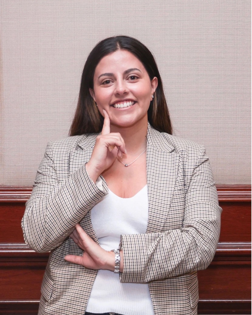 Retrato de María José Araya, sonriendo, con una chaqueta de cuadros.
